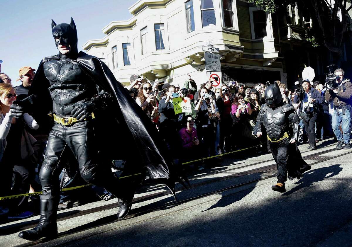 Miles Scott, dressed as Batkid, right, runs with Batman after saving a damsel in distress in San Francisco, Friday, Nov. 15, 2013. San Francisco turned into Gotham City on Friday, as city officials helped fulfill Scott's wish to be "Batkid."Â Scott, a leukemia patient from Tulelake in far Northern California, was called into service on Friday morning by San Francisco Police Chief Greg Suhr to help fight crime, The Greater Bay Area Make-A-Wish Foundation says. (AP Photo/Jeff Chiu)