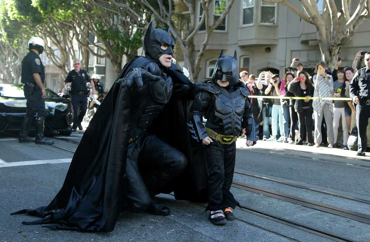 Miles Scott, dressed as Batkid, right, walks with Batman before saving a damsel in distress in San Francisco, Friday, Nov. 15, 2013. San Francisco turned into Gotham City on Friday, as city officials helped fulfill Scott's wish to be "Batkid."Â Scott, a leukemia patient from Tulelake in far Northern California, was called into service on Friday morning by San Francisco Police Chief Greg Suhr to help fight crime, The Greater Bay Area Make-A-Wish Foundation says. (AP Photo/Jeff Chiu)
