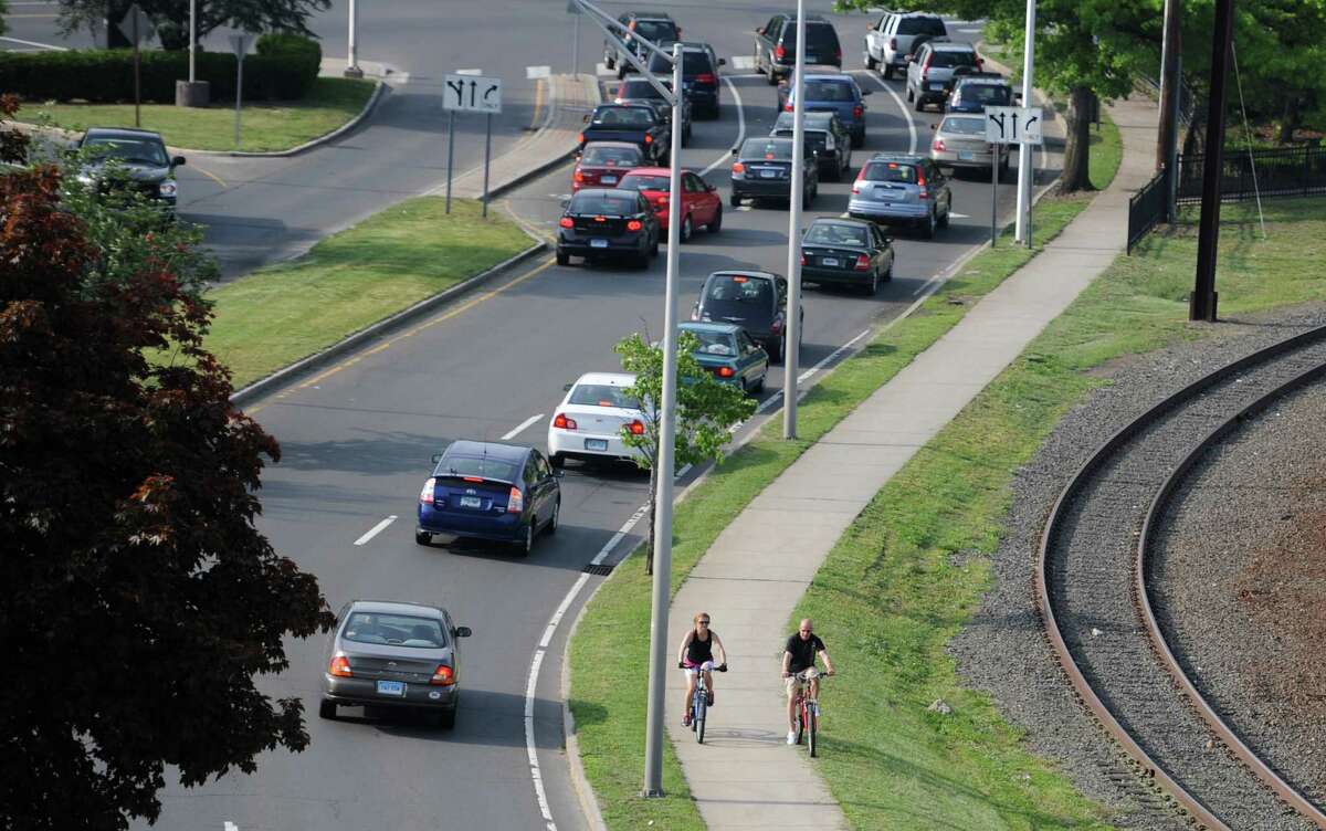 People ride bikes while others are stuck in traffic in Danbury, Conn. the evening of Wednesday, May 22, 2013. Figures released by the U.S. Census Bureau state that Danbury is the fastest-growing city in Connecticut. The state of Connecticut grew by roughly 13,700 residents between July 2010 and July 2012, remaining the nation's 29th most populated state.