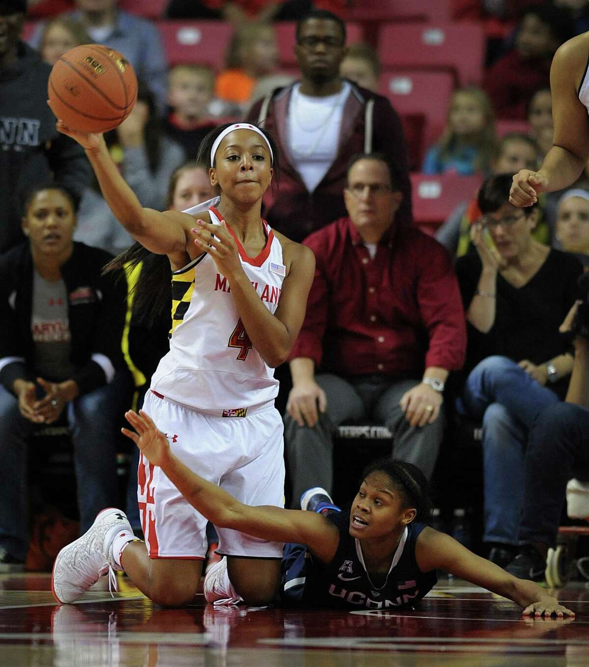 Maryland's Lexie Brown, left, passes from her knees as Connecticut's Moriah Jefferson struggles to block in the second half of an NCAA basketball game Friday, Nov. 15, 2013 in College Park, Md. Connecticut won 72-55.(AP Photo/Gail Burton)