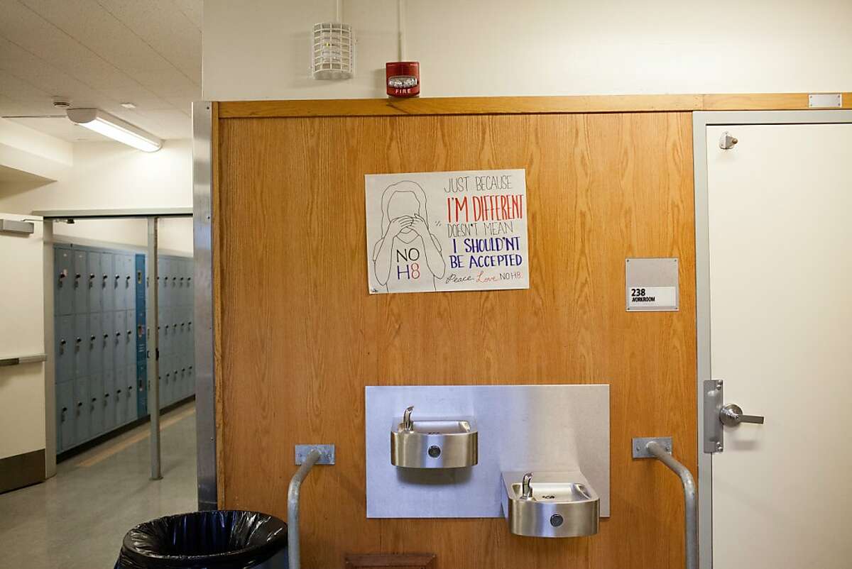 A sign hanging above a water fountain in Oakland High School, where Richard Thomas attended school, reads "Just because I'm different doesn't mean I shouldn't be accepted, Please Love No H8 (No Hate)" in Oakland, Calif., Thursday, November 14, 2013.