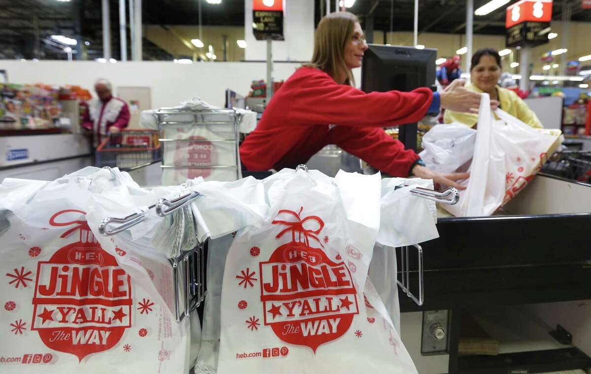Rickie Rosales, a checker at the HEB at 2118 Fredericksburg Rd, helps shopper Marta Rdriguez with her groceries loaded in plastic bags. Wednesday, Nov. 13, 2013.