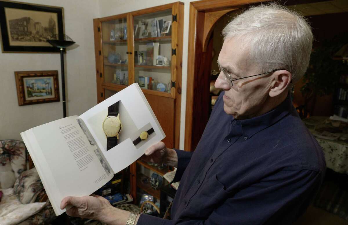 Ed O'Brien holds a book of JFK auction at his home Friday morning Nov. 15, 2013 in Troy, N.Y. These items were from a 1989 auction. (Skip Dickstein / Times Union)