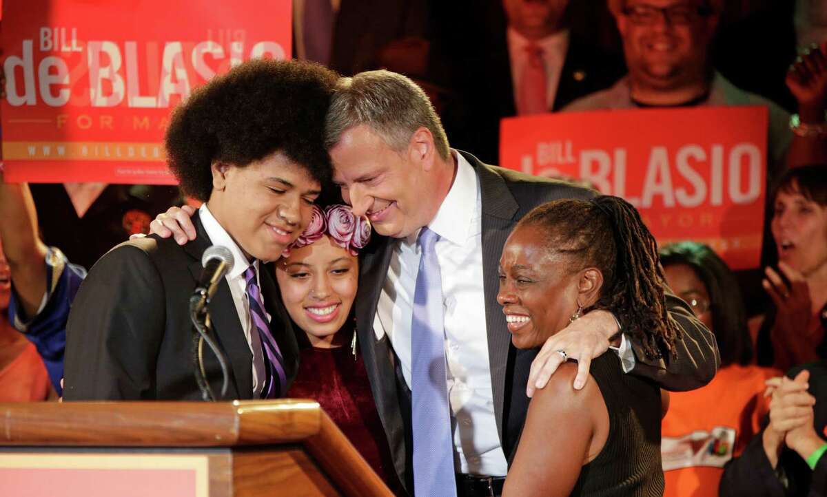 New York Democratic Mayor-elect Bill de Blasio embraces his son Dante, left, daughter Chiara, and wife Chirlane McCray after the polls closed.
