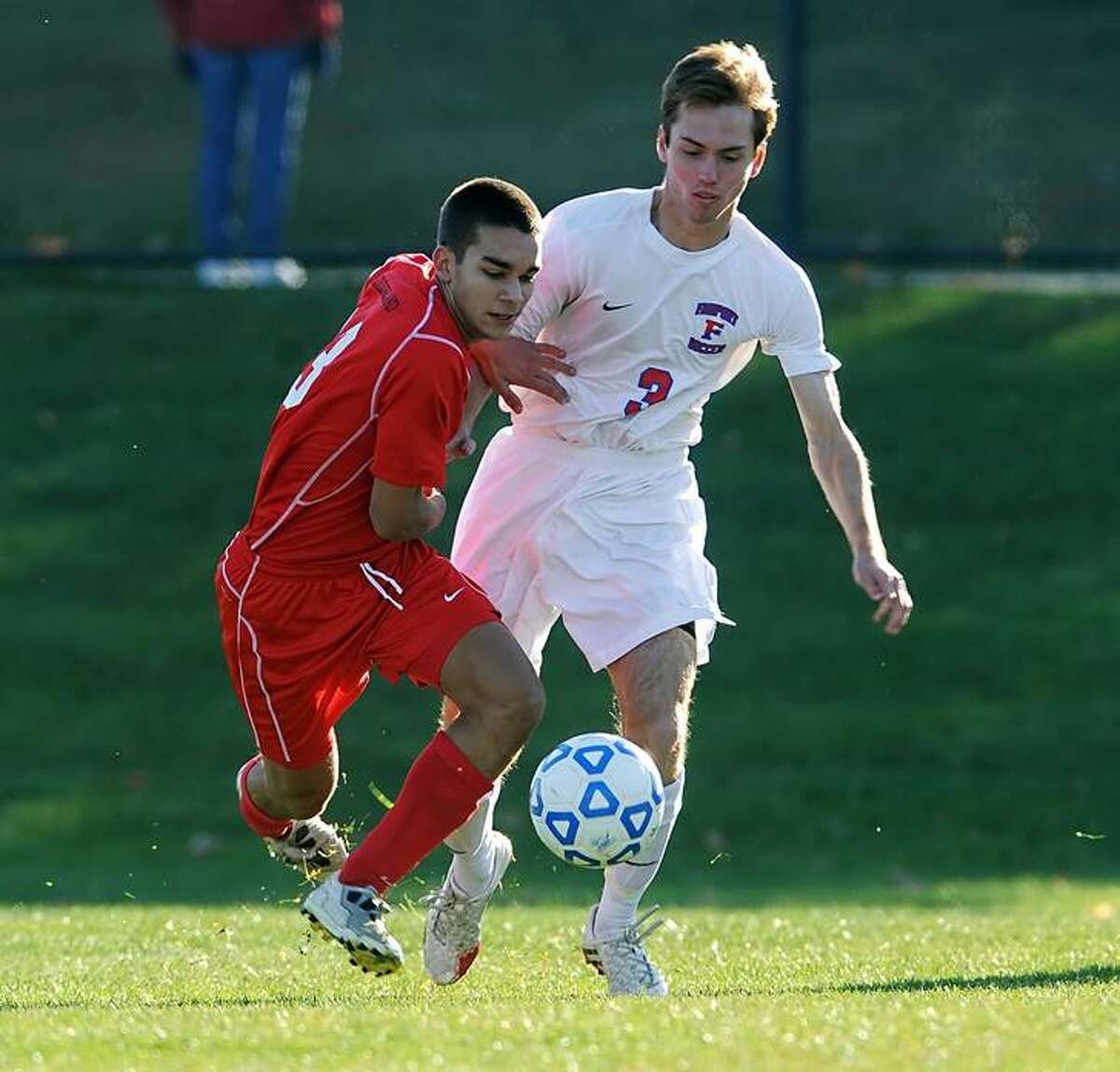Guilderland's Daniel Dibiase, left, battles for the ball against Fairport's Alex Mangerian in a Class AA state semifinal at Middletown High School on Saturday, Nov. 16, 2013. Fairport advances to the Class AA final after beating Guilderland, 3-1. (Adrian Kraus / Special to the Times Union)