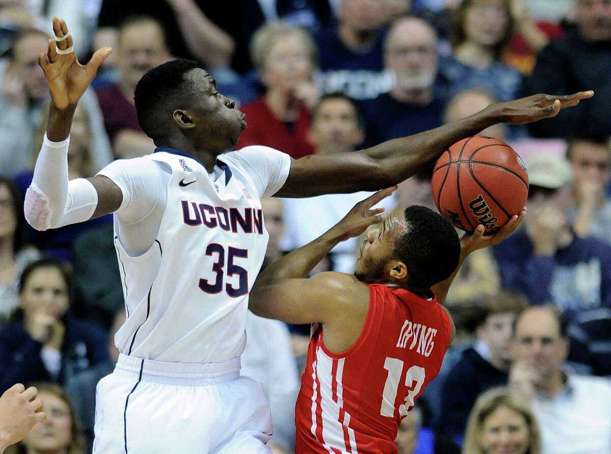 Connecticut's Amida Brimah (35) attempts to block the shot of Boston University's D.J. Irving (13) during the first half of an NCAA college basketball game in Storrs, Conn., on Sunday, Nov. 17, 2013.