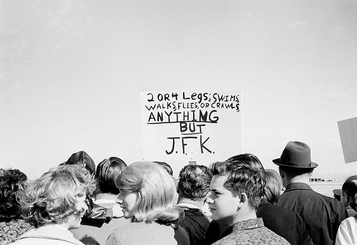Anti-Kennedy protesters with placards are seen among the throngs of supporters that came out to Love Field in Dallas, Tex., to see the president arrive, Nov. 22, 1963. (AP Photo)