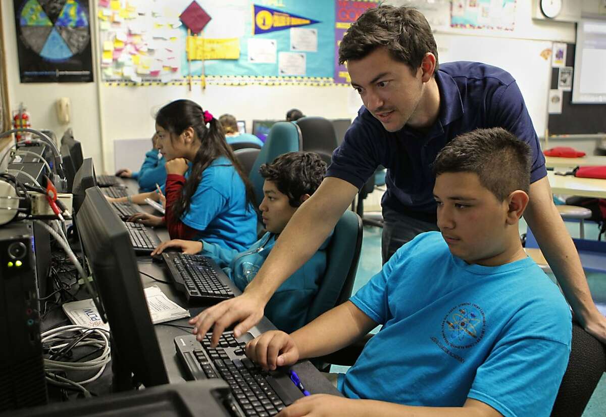 Instructor of engineering and technology, Petrut Ababei, helps out 7th grade student Roberto Gutierrez at the Lazear Charter Academy in Oakland, Ca., on Tuesday Nov. 12, 2013. Lazear is among 40 charter schools throughout the City of Oakland. One school board member has decided to vote against allowing any new charter schools.