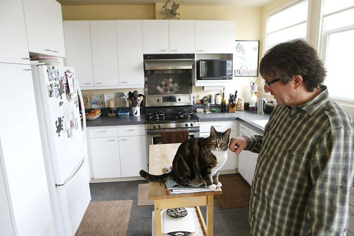 Richard Goldman, a nearly 24-year survivor of Anal Neoplasia, pets his cat at his home on Thursday, November 14, 2013 in San Francisco, Calif.