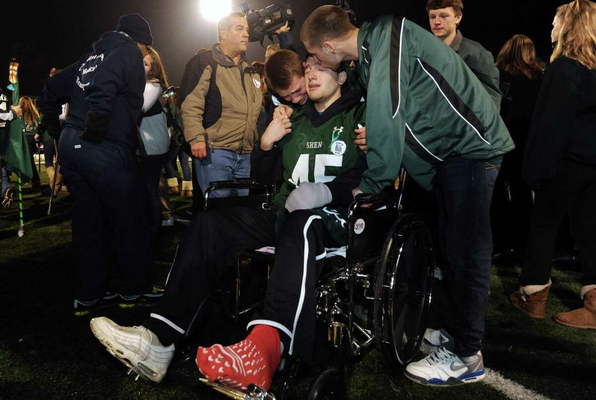 Crash survivor Matt Hardy, center, is greeted by football teammates after arriving by medical van during a candlelight vigil and memorial service for the Shen crash victims at Shenendehowa High School in Clifton Park, NY Tuesday Dec. 4, 2012. Shen students Chris Stewart and Deanna Rivers died in the crash with Matt Hardy and Bailey Wind being seriously injured.(Michael P. Farrell/Times Union)