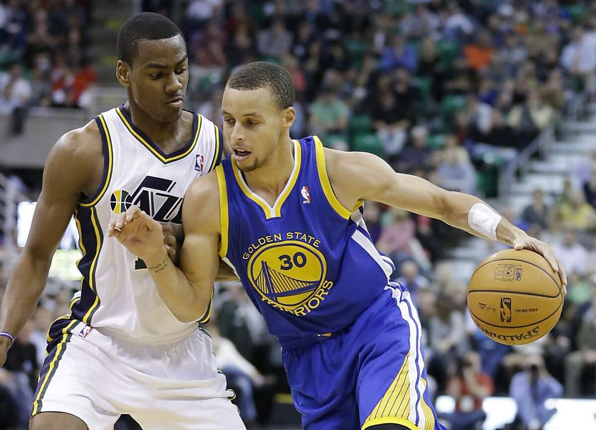 Utah Jazz's Alec Burks, left, defends against Golden State Warriors' Stephen Curry (30) as he drives in the second quarter during an NBA basketball game Monday, Nov. 18, 2013, in Salt Lake City. (AP Photo/Rick Bowmer)