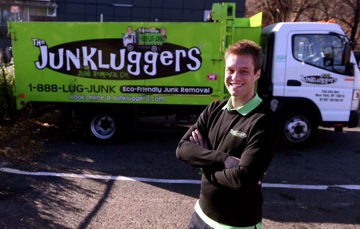Josh Cohen, founder and CEO of Junkluggers, stands in front of one of his trucks at the company's Norwalk office.