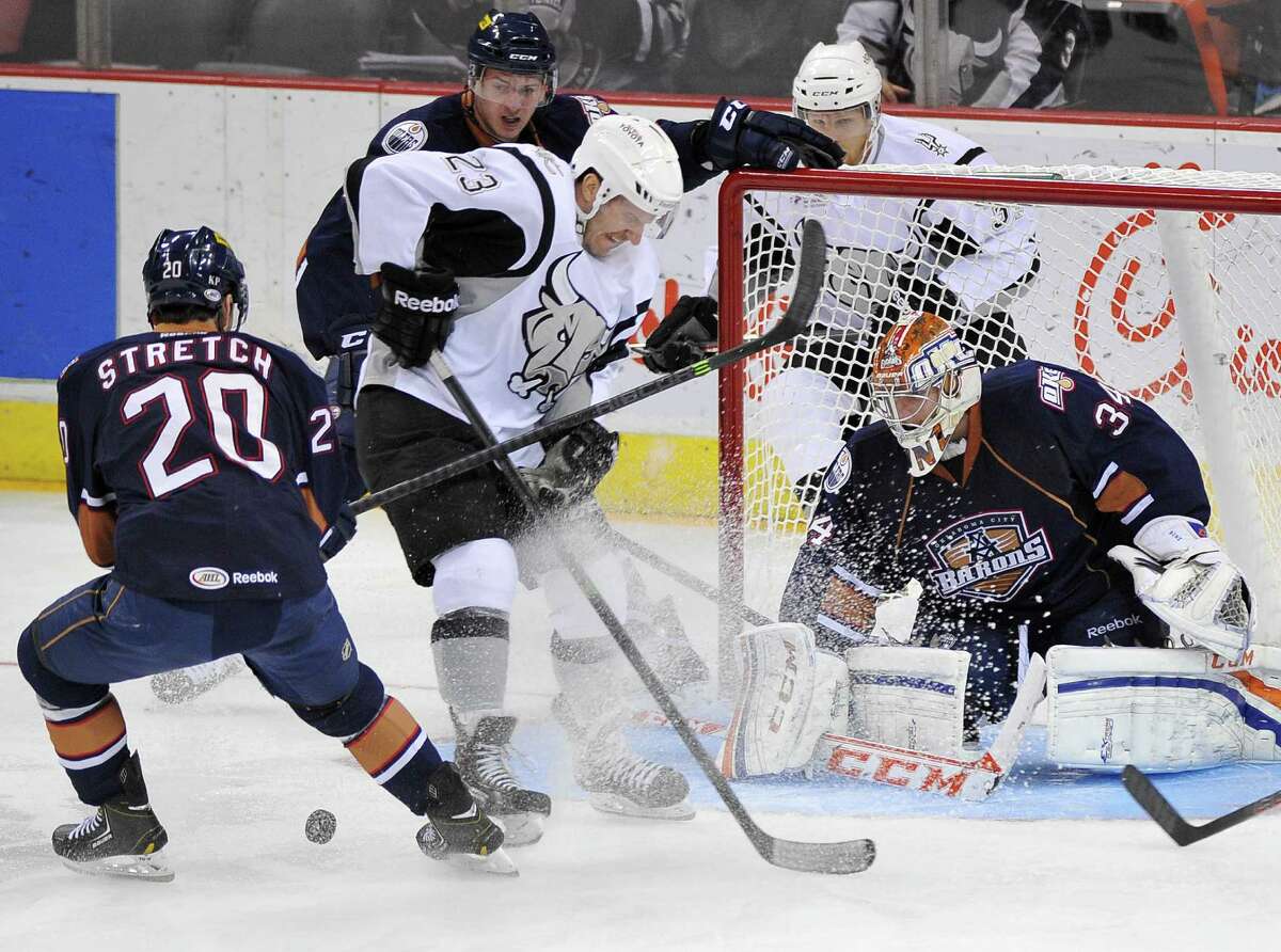Oklahoma City goaltender Tyler Bunz eyes the puck as Rampage winger Jack Combs (23) crashes the net during the first period at the AT&T Center. Combs had an assist in the win.