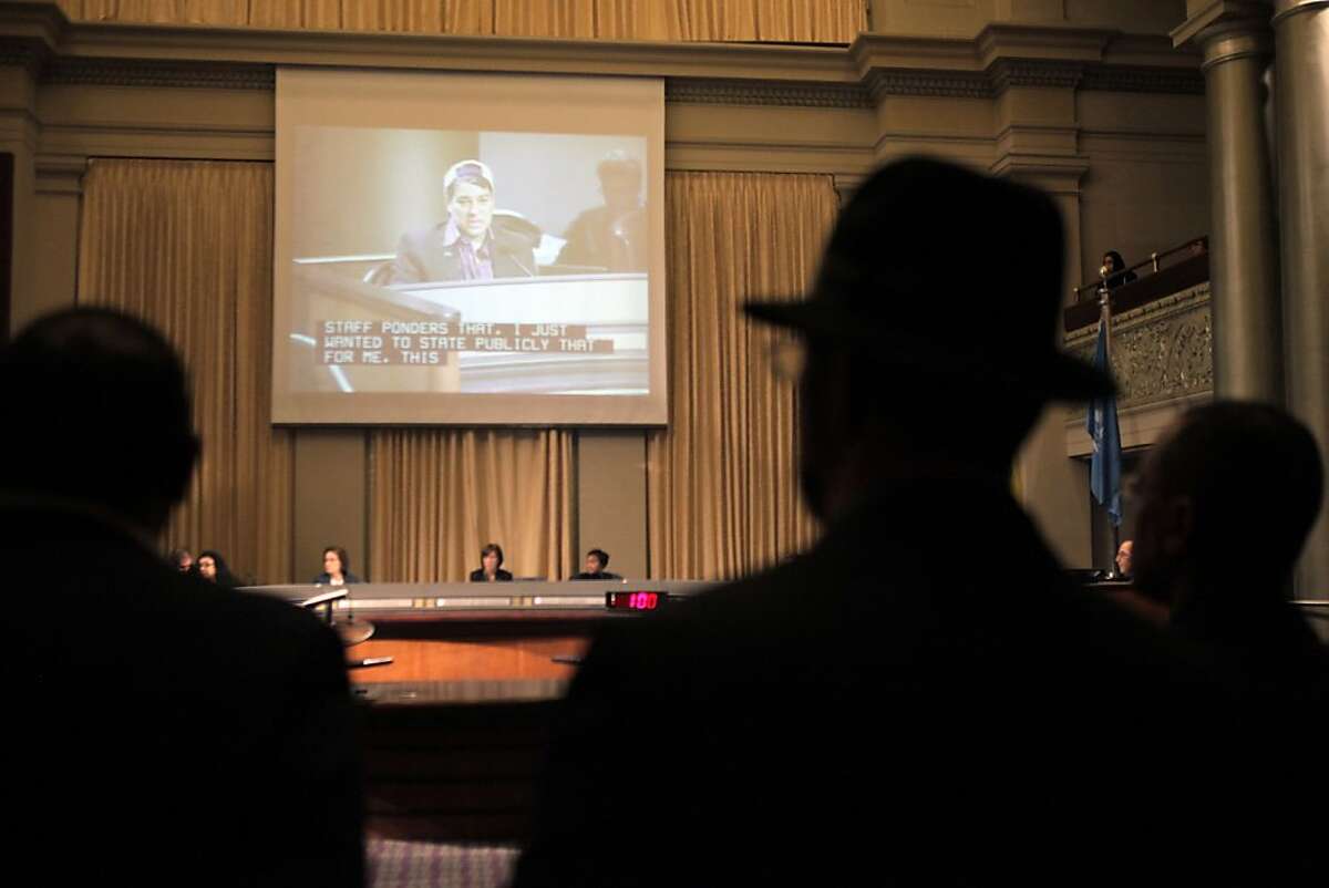 Oakland residents listen to agenda items early on during the city council meeting on Tuesday. about three dozen residents opposed to the planned Domain Awareness Center in Oakland, Calif., spoke out during the Oakland City Council meeting on Tuesday, November 19, 2013. The council planned Tuesday to move ahead with the DAC , which the city says it a federally funded center to help them better monitor crime and protests but critics call the "creepy Oakland spy center" which they say is really a surveillance center to spy on private citizens.