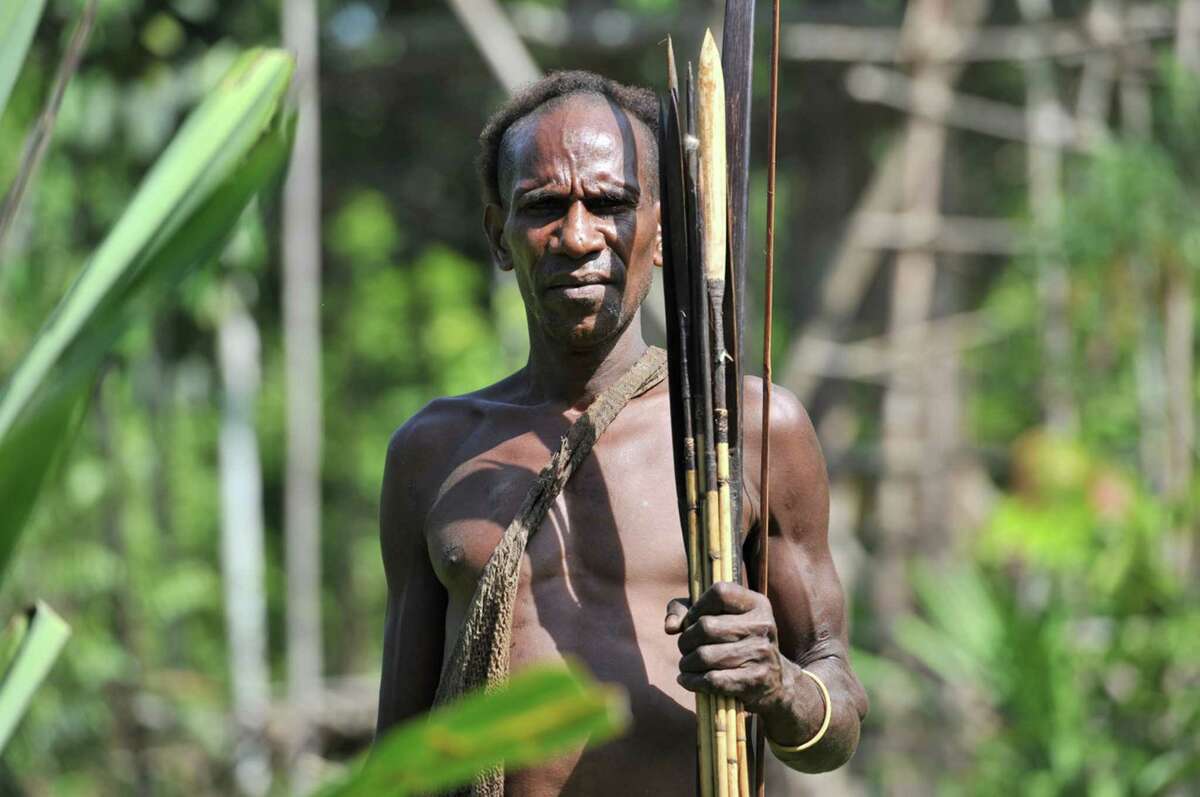 Cos Cob resident Luc Hardy recently traveled to a remote jungle village in West Papua, New Guinea, where encountered members of the Korowai tribe, a primitive group of hunter/gatherers that number about 3,000. Above, a Korowai hunter displays his weapons.