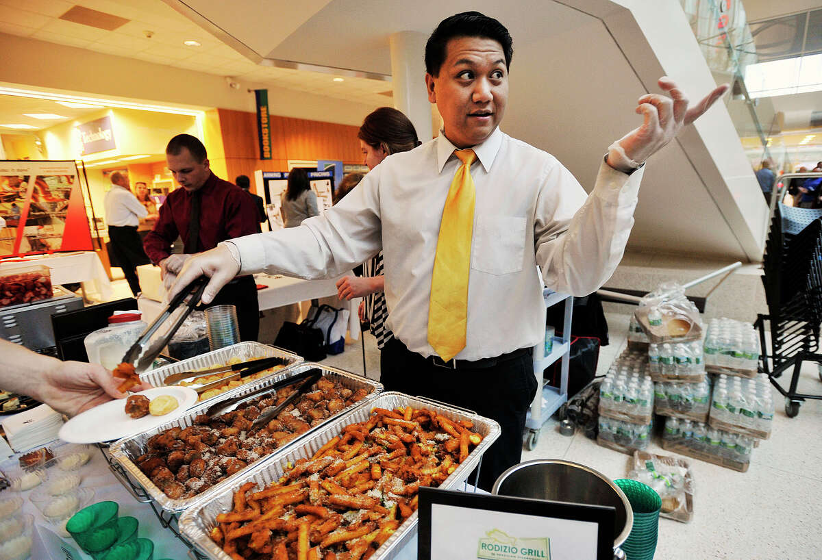 Jerome Liamzon, representing Rodizio Grill of Stamford, points accross the street to their restaurant location while handing out samples of the restaurant's food during the Quad Chamber of Commerce Expo at Stamford UConn in Stamford, Conn., on Thursday, Nov. 21, 2013.