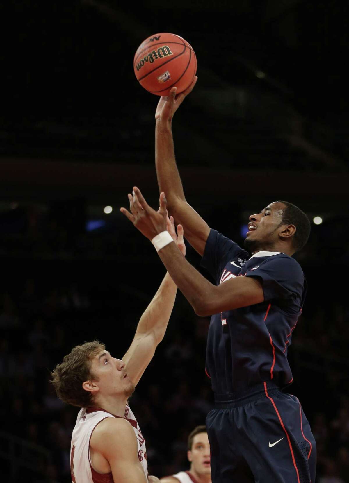 Connecticut's DeAndre Daniels, right, shoots over Boston College's Eddie Odio during the first half of an NCAA college basketball game on Thursday, Nov. 21, 2013, in New York.