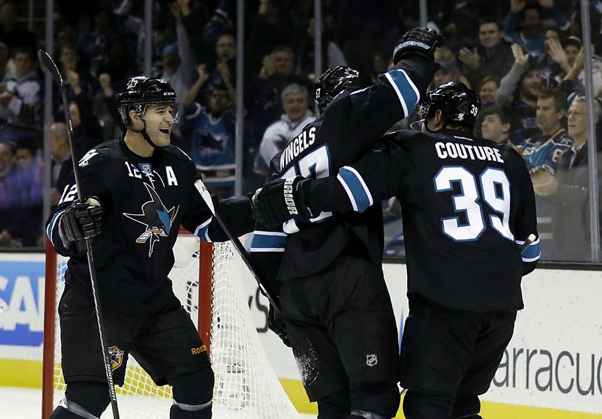 San Jose Sharks' Tommy Wingels, center, is hugged by teammates Patrick Marleau, left, and Logan Couture after Wingels' score against the Tampa Bay Lightning during the first period of an NHL hockey game on Thursday, Nov. 21, 2013, in San Jose, Calif. (AP Photo/Marcio Jose Sanchez)