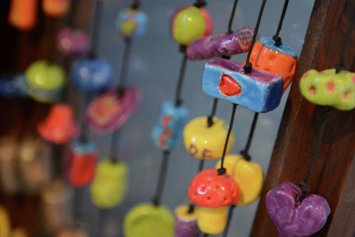 A painted heart, and other colorful ceramic decorations adorn the strings of Ben's Bells at Ben's Bells Studio in Newtown, Conn. on Wednesday, Nov. 20, 2013. Ben's Bells are colorful, ceramic pieces of art hung in public places with tags instructing the finder to take the bell home with them and remember to be kind. The project was started by a family in Arizona after losing their child, Ben, before his third birthday. The studio in Newtown is the only one outside of Arizona.