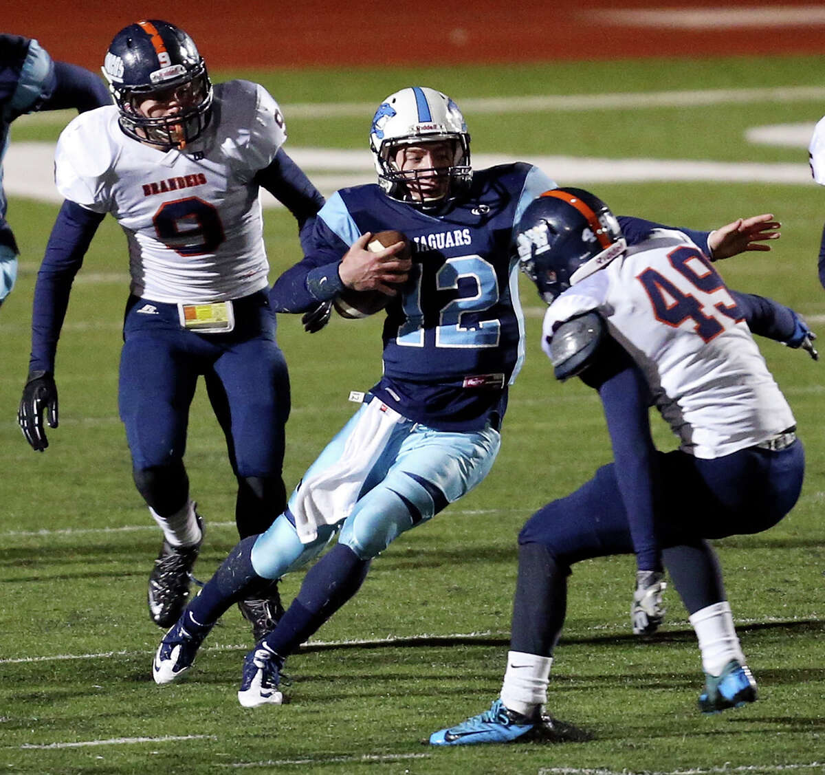 Johnson's Hunter Rittimann looks for room between Brandeis' Brandon Smyth (left) and Darien Dunn during second half action of their Class 5A Division II area playoff game Friday Nov. 22, 2013 at Heroes Stadium. Johnson won 23-17 in overtime.