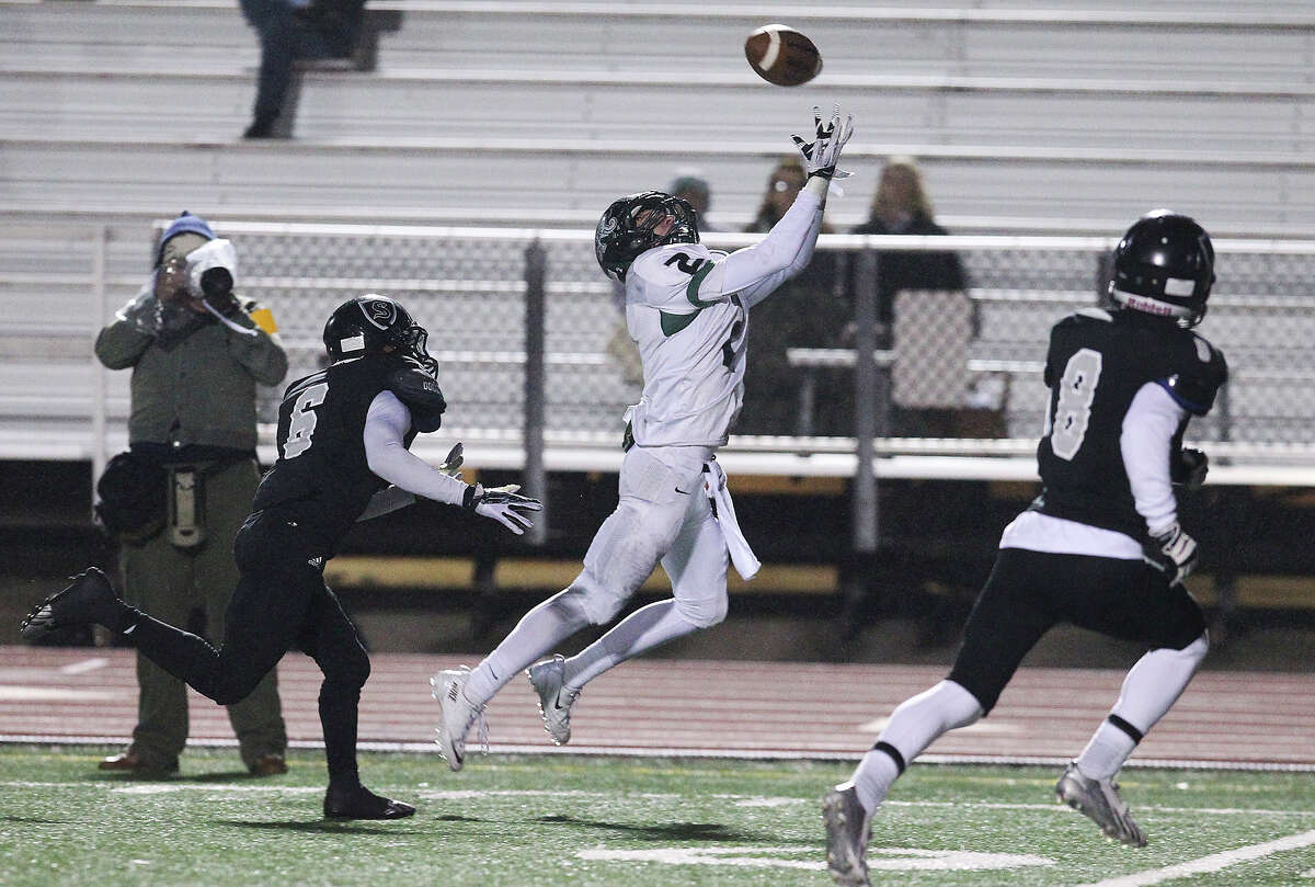 Reagan's Connor Heffron (02) reaches for a pass against Steele's Alvin Johnson (06) during their 5A playoff game at Comalander Stadium on Friday, Nov. 22, 2013.