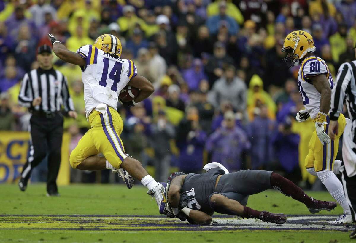 Texas A&M defensive back Howard Matthews (31) tries to tackle LSU running back Terrence Magee (14) on a long carry in the first half of an NCAA college football game in Baton Rouge, La., Saturday, Nov. 23, 2013. (AP Photo/Gerald Herbert)