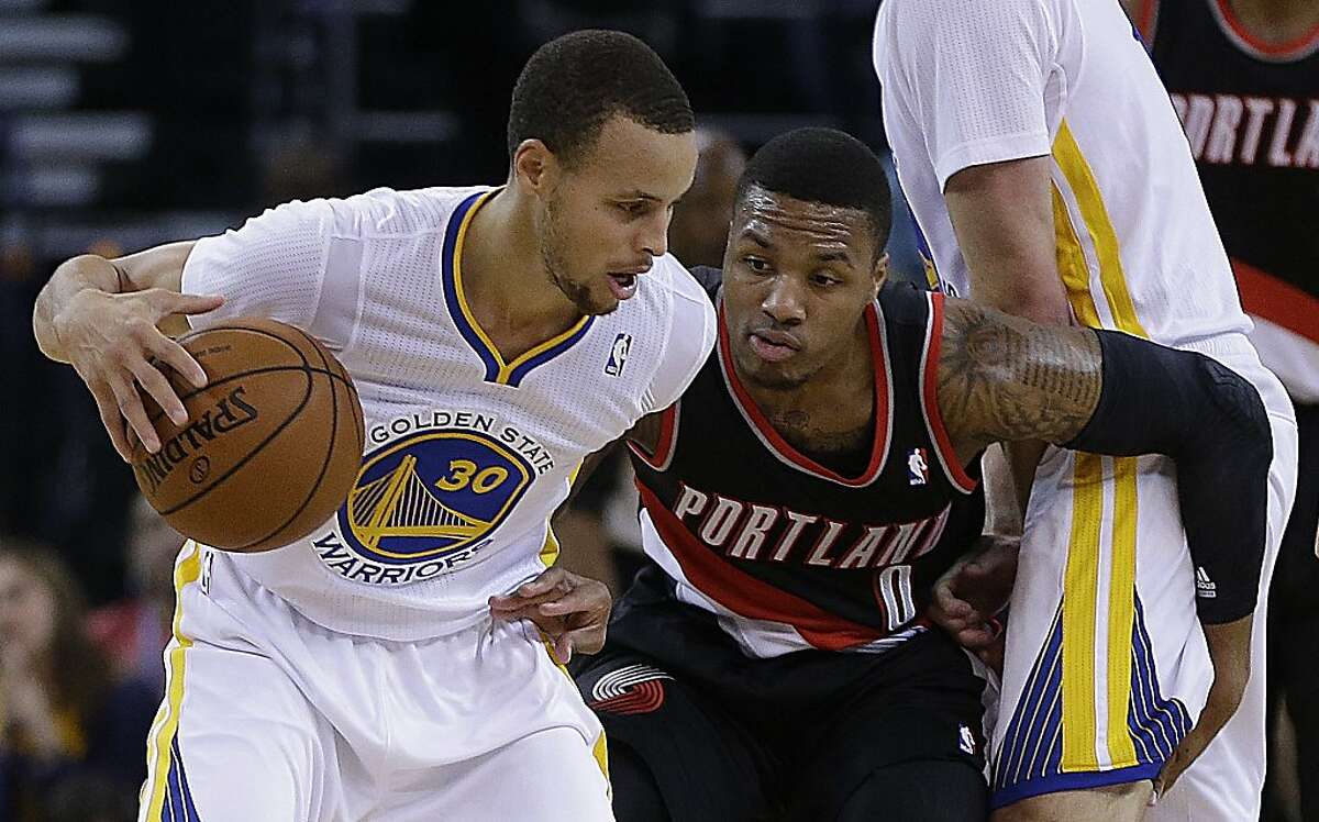Golden State Warriors' Stephen Curry (30) keeps the ball from Portland Trail Blazers' Damian Lillard, right, during the first half of an NBA basketball game Saturday, Nov. 23, 2013, in Oakland, Calif. (AP Photo/Ben Margot)