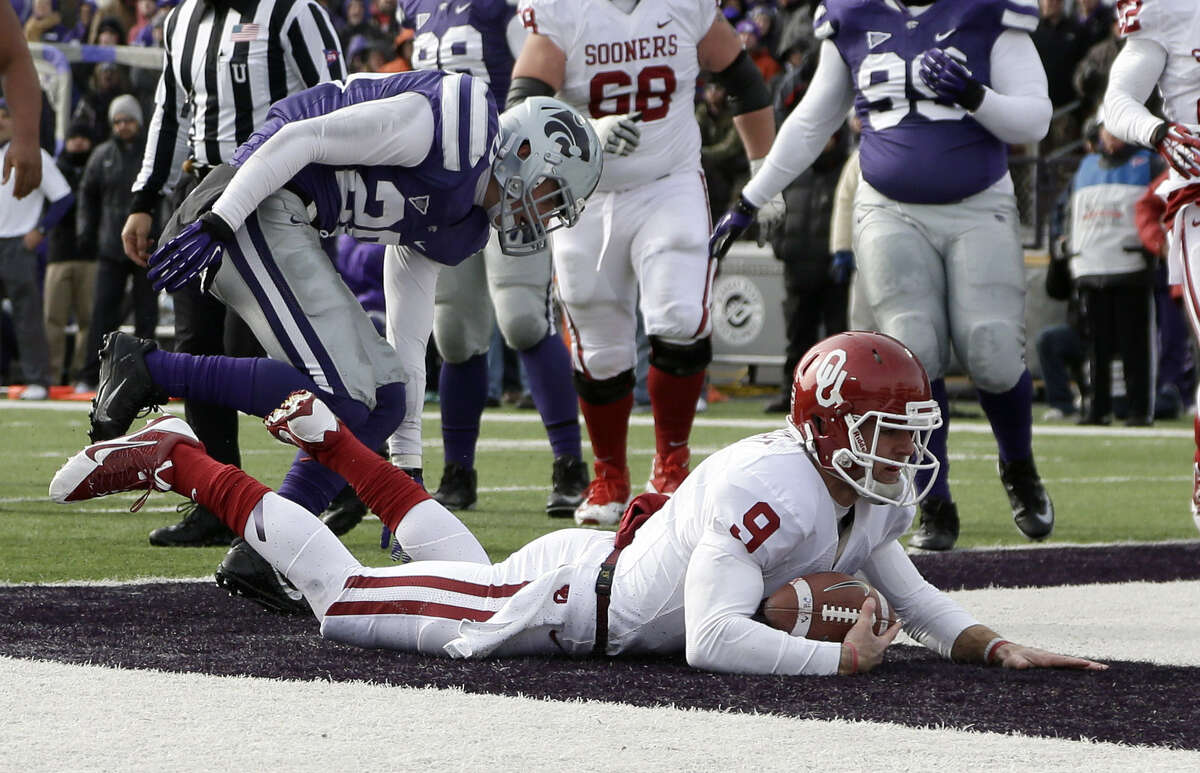 Oklahoma quarterback Trevor Knight dives past Kansas State defensive back Dylan Schellenberg to score a touchdown during the first half.