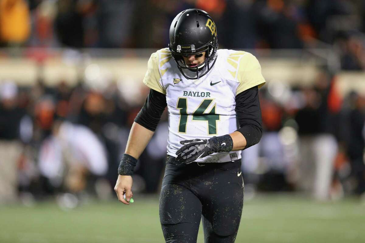 STILLWATER, OK - NOVEMBER 23: Bryce Petty #14 of the Baylor Bears walks off the field after Tyler Patmon #26 of the Oklahoma State Cowboys returned a fumble for a touchdown in the fourth quarter at Boone Pickens Stadium on November 23, 2013 in Stillwater, Oklahoma.