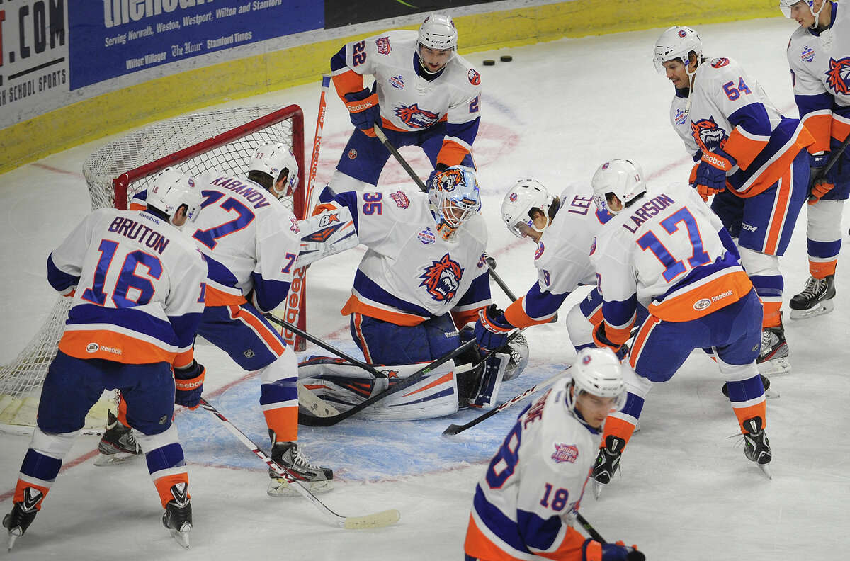 Sound Tigers goalie Kenny Reiter is surrounded as his teammates try to knock the puck home during pre-game warmups at the Webster Bank Arena in Bridgeport, Conn. on Sunday, November 24, 2013.