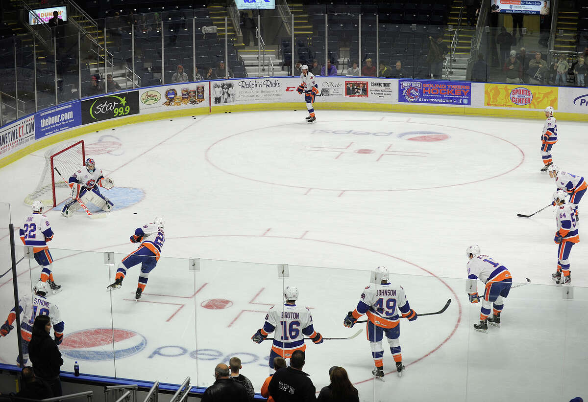 Sound Tigers goalie Kenny Reiter fields shots on goal from a circle of his teammates during pre-game warmups at the Webster Bank Arena in Bridgeport, Conn. on Sunday, November 24, 2013.
