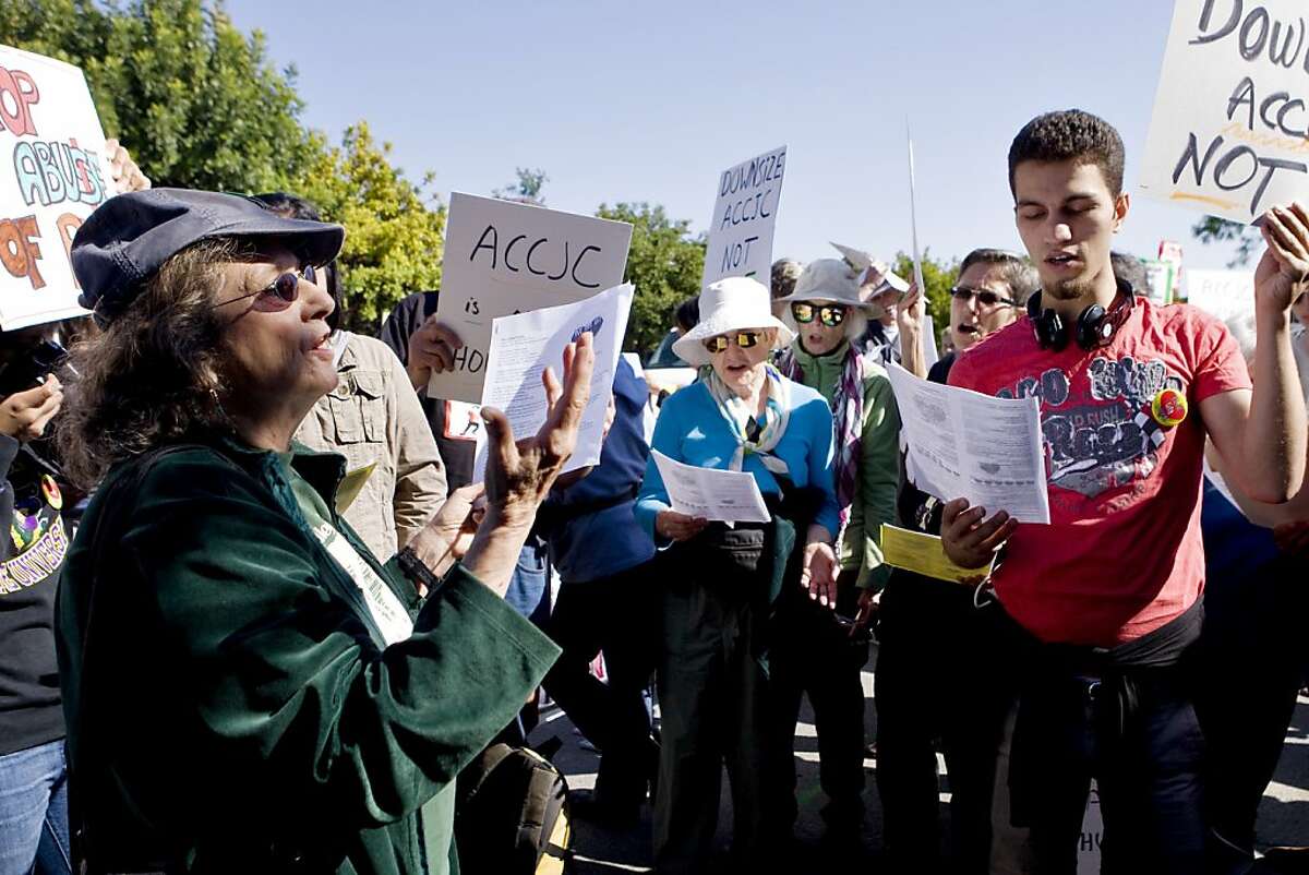 Pat Wynne leads protestors in a song at the Accrediting Commission for Community and Junior Colleges headquarters in Novato, Ca, on Friday, Oct. 11, 2013.
