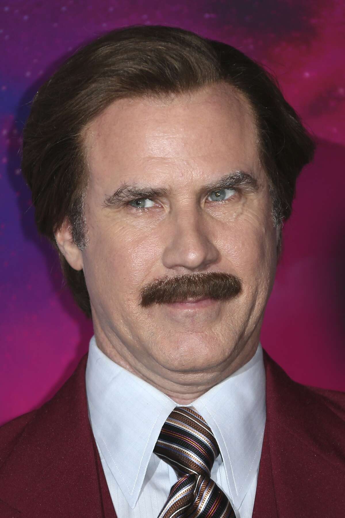 FILE - In this Nov. 10, 2013 file photo, actor Will Ferrell, dressed as the character Ron Burgundy, poses for photographers upon arrival at the 2013 MTV Europe Music Awards, in Amsterdam, Netherlands. Ferrell's fictitious “Anchorman” character, will help cover Canada's Olympic curling trials for broadcaster TSN. (Photo by Joel Ryan/Invision/AP)