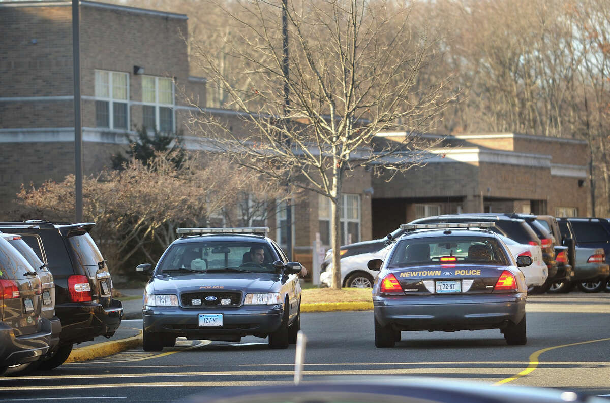 A pair of Newtown police cruisers man the entrance to Hawley School at 29 Church Hill Road in Newtown, Conn. on Monday, November 25, 2013, the day the state's attorney's report of the Sandy Hook Elementary School shootings was released.