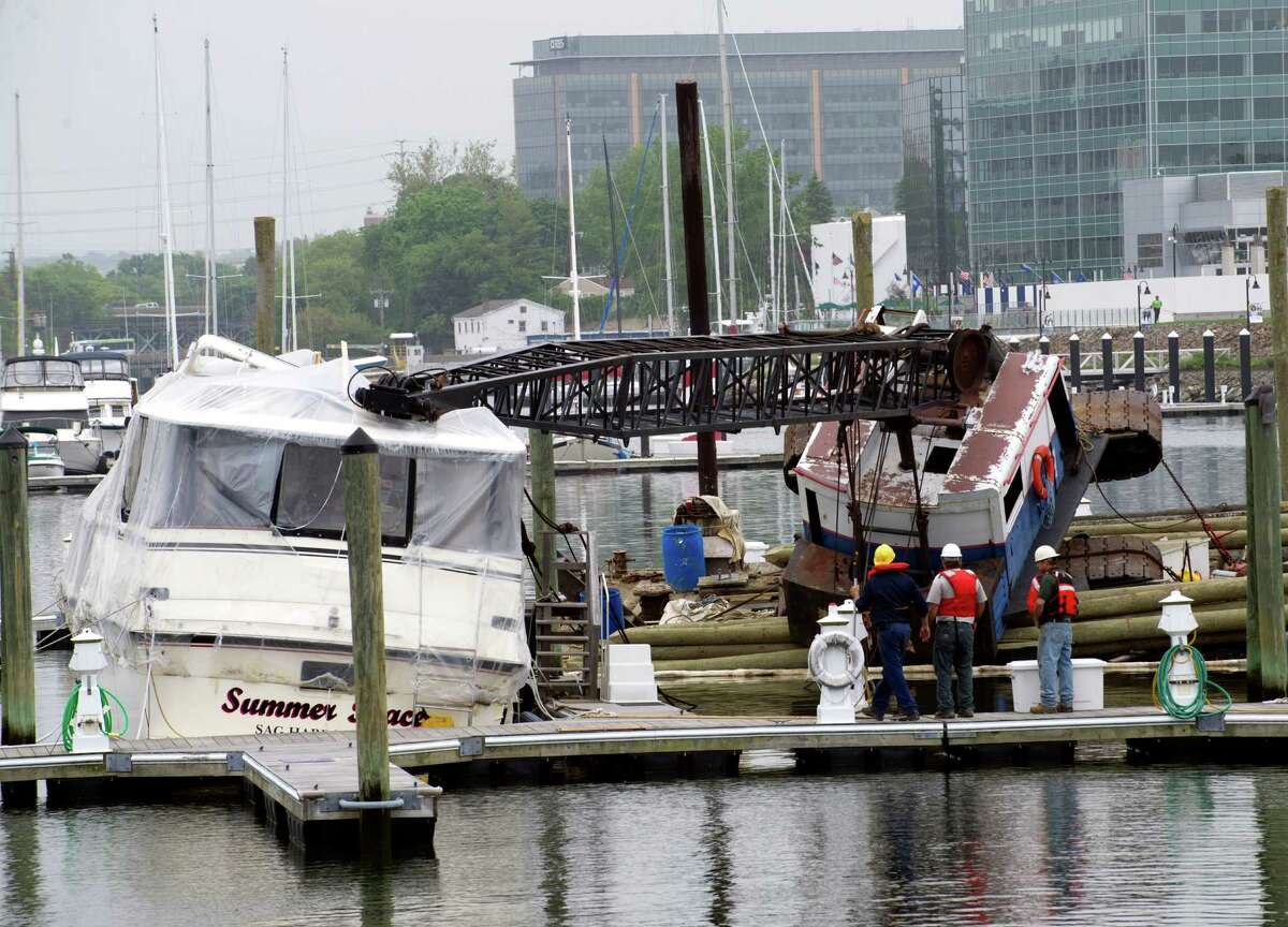 A crane lays collapsed on top of a yacht at Avalon on Stamford Harbor on Wednesday, May 22, 2013.