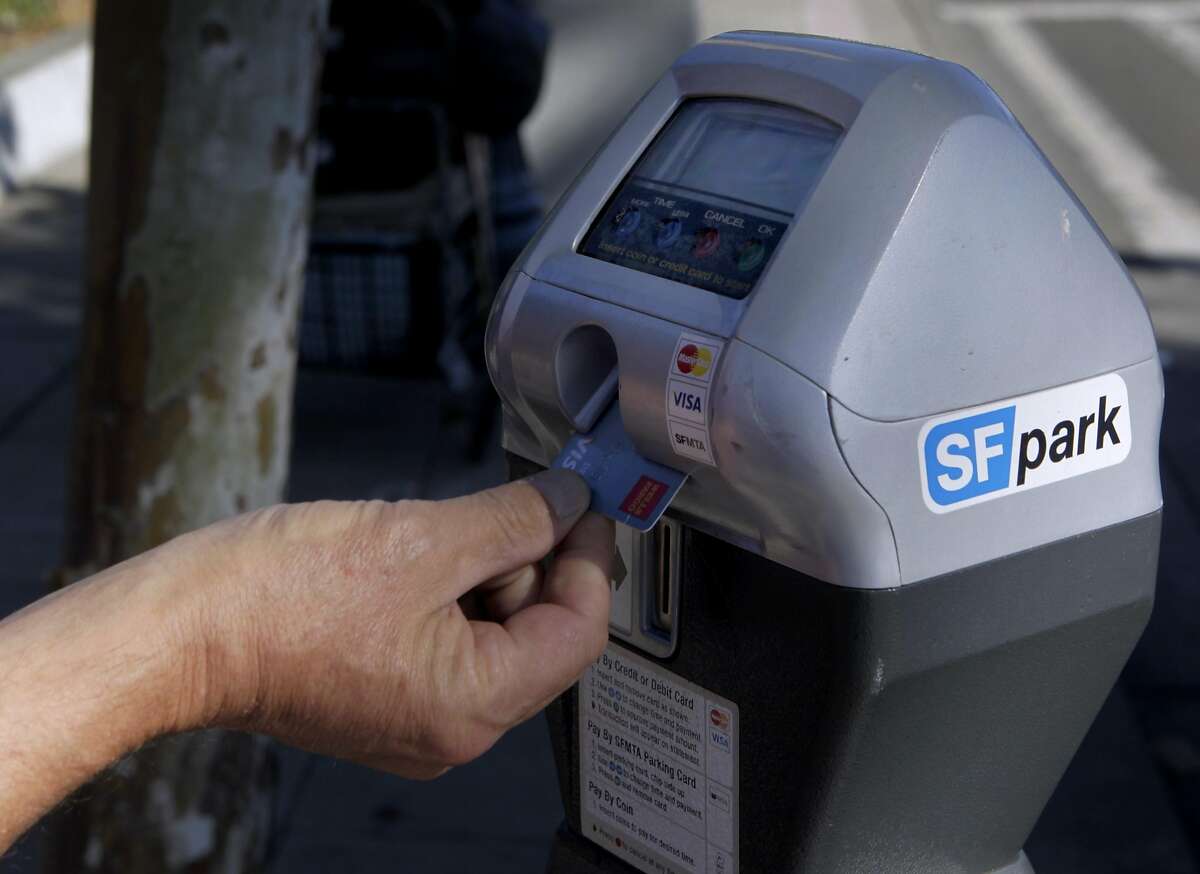 A commuter uses a debit card to pay for a parking meter on The Embarcadero in San Francisco, Calif. on Friday, June 28, 2013. The violation for parking at expired meters jumps to $74 on July 1, making it the most expensive fine in the country.