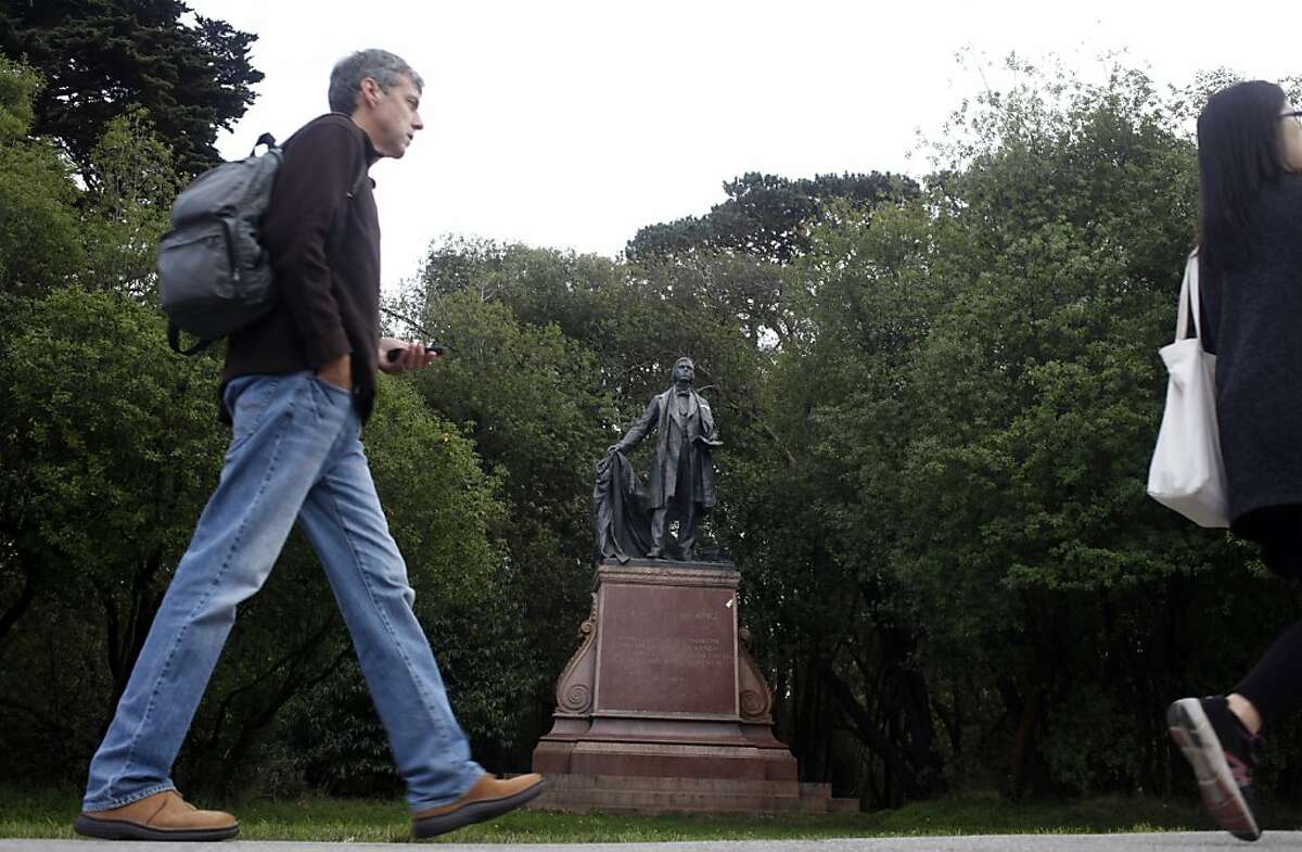 2013年11月26日星期二，加州旧金山金门公园，人们走过19世纪一神论牧师托马斯·斯塔尔·金的雕像。