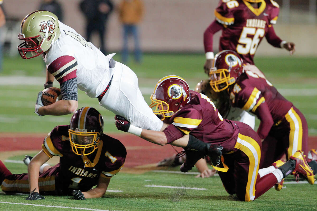 Harlandale's Ruben Zavala (bottom right) tackles Leander Rouse quarterback Billy Ray McCrary during the third quarter of their Class 4A Division I third round playoff game at Bobcat Stadium in San Marcos on Friday, Nov. 29, 2013. Leander Rouse beat Harlandale 43-21.