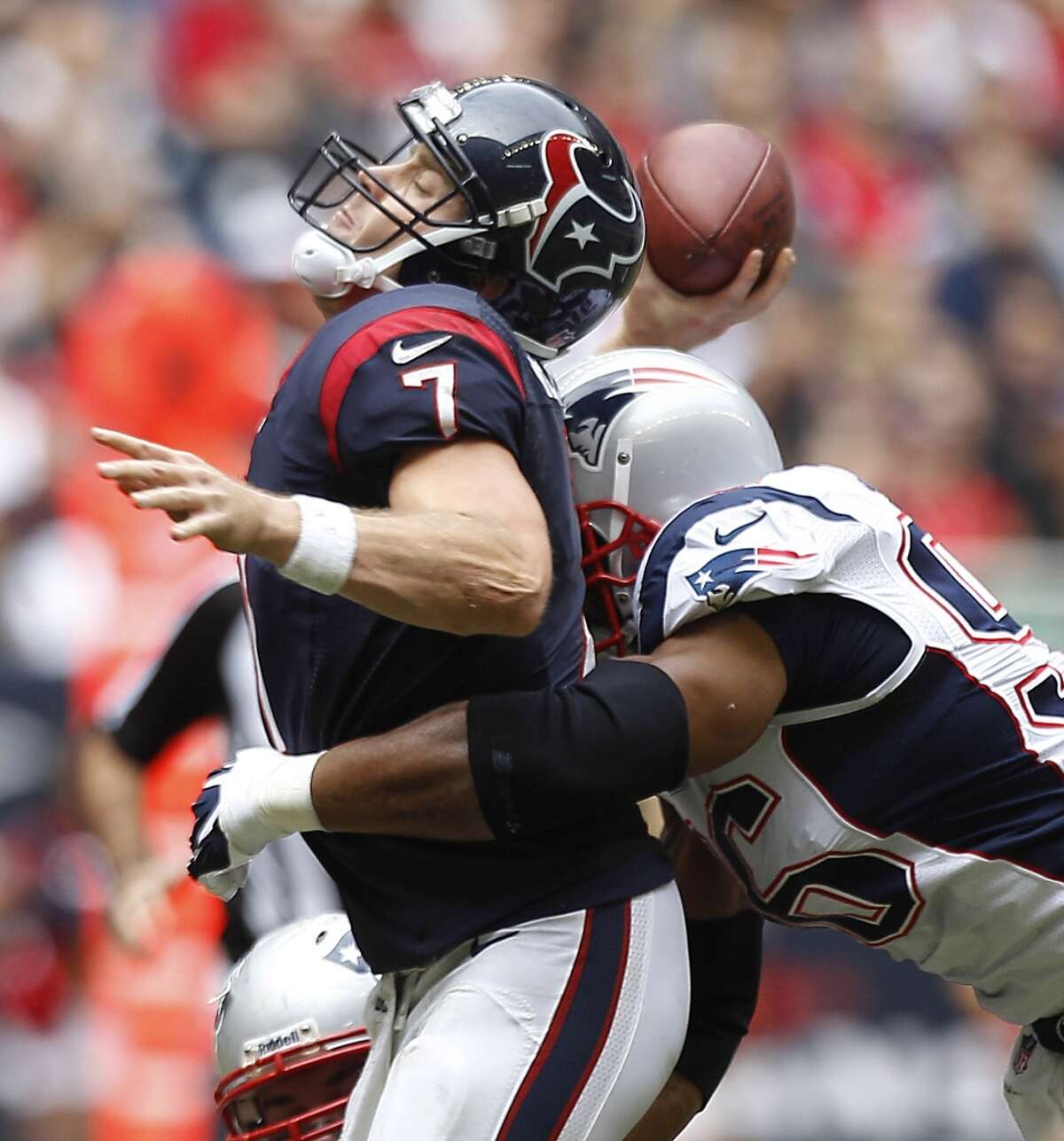 Texans quarterback Case Keenum is hit by Patriots defensive end Andre Carter as he releases a pass during the second quarter.