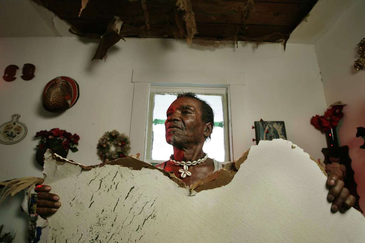 Cleveland Turner holds part of the ceiling inside his home that collapsed from the effects of Hurricane Ike Oct. 2, 2008 in Houston. Hurricane Ike damaged the house of African yard artist Cleveland Turner, aka The Flower Man. The orange show foundation is calling for a Saturday work day to make repairs. Oct. 2, 2008 ( Eric Kayne / Chronicle )
