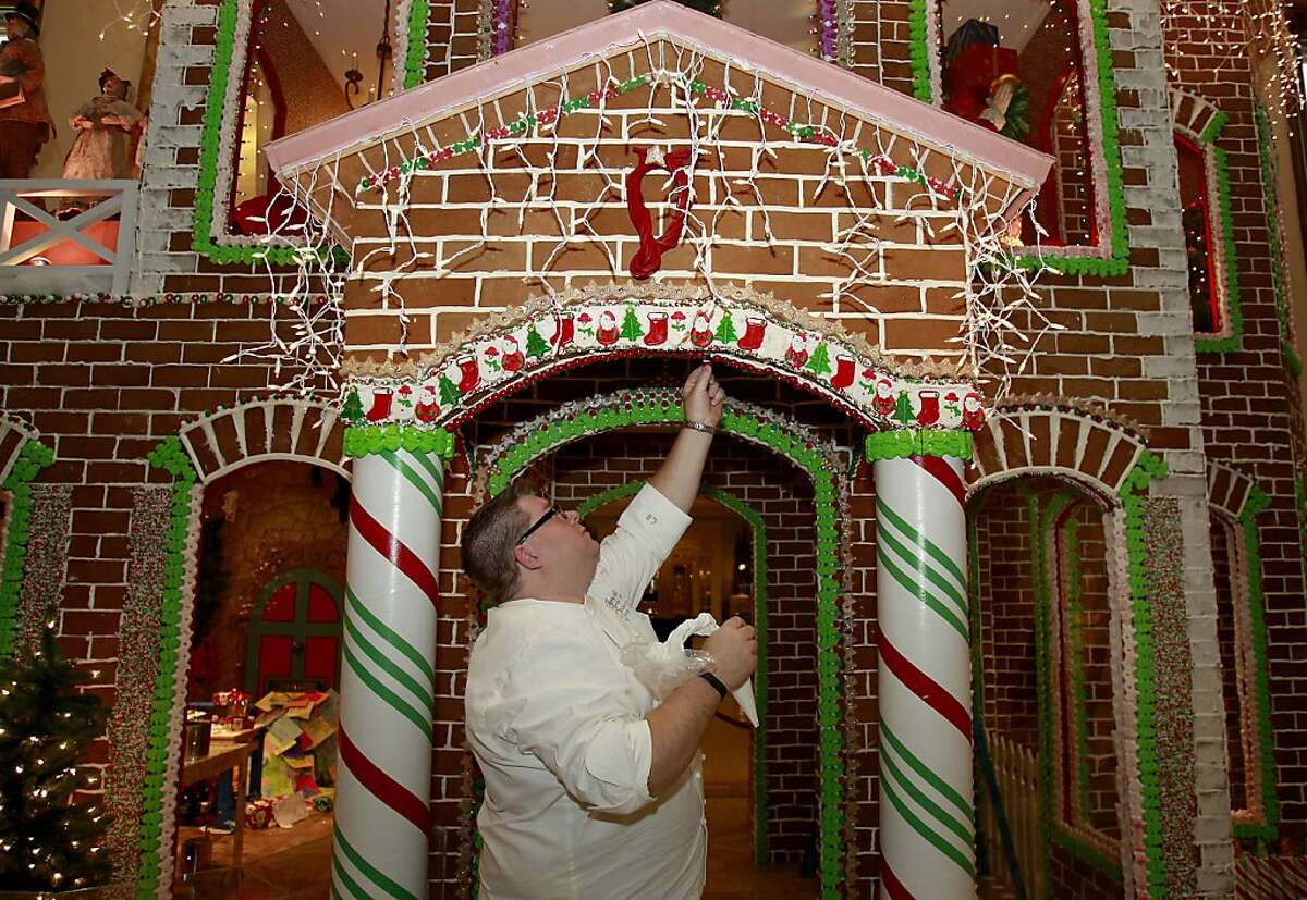 Fairmont Executive Chef Chad Blunston makes a little repair on his gingerbread house Thursday November 27, 2013 in San Francisco, Calif. The Fairmont Hotel on Nob Hill is finishing up it's famous gingerbread house which takes up a prominent place in the lobby along with other Christmas scenes.