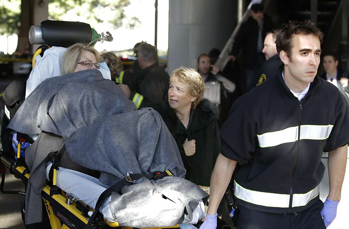 An inured passenger is taken to an ambulance at the Rockridge BART station in Oakland, Calif. on Wednesday, Dec. 4, 2013 after a westbound train became stranded in the Berkeley Hills tunnel. Several commuters were transported to local hospitals.