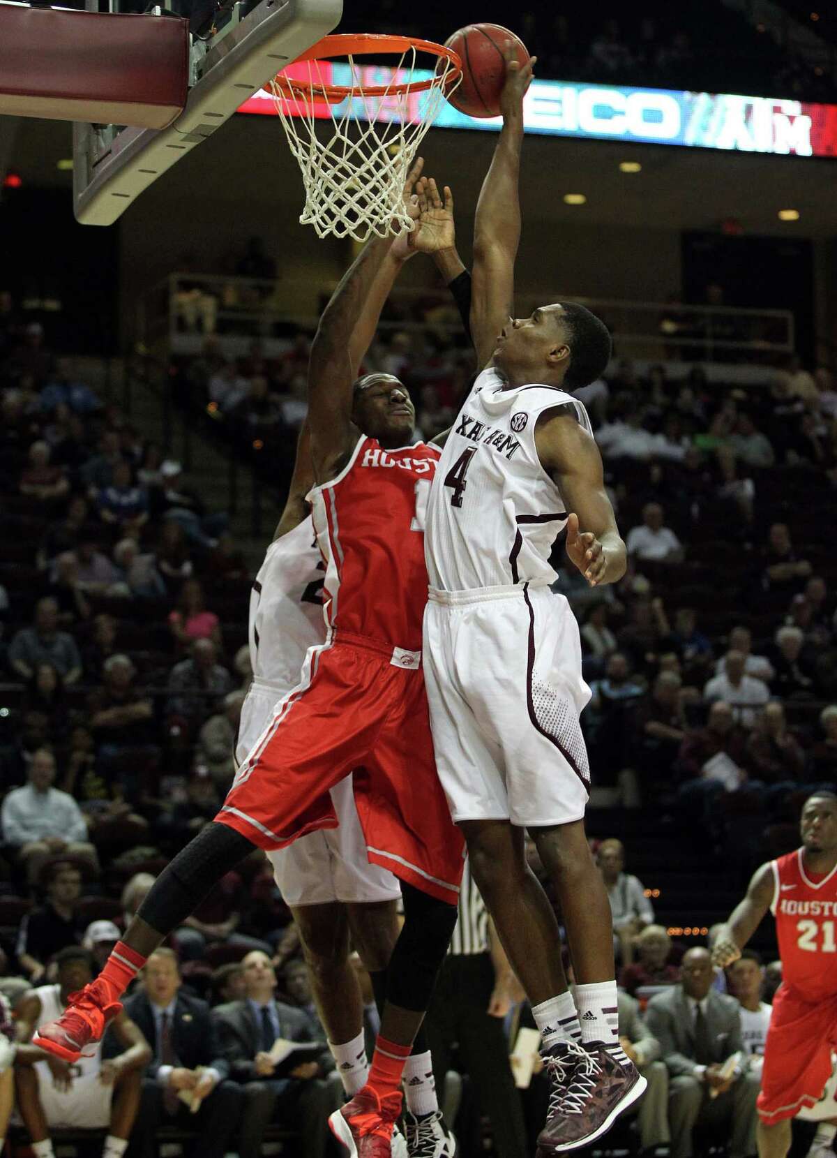Houston's Mikhail McLean, left, fights for a rebound with Texas A&M's Tavario Miller during the first half of an NCAA college basketball game, Wednesday, December 3, 2013, at Reed Arena in College Station, TX.