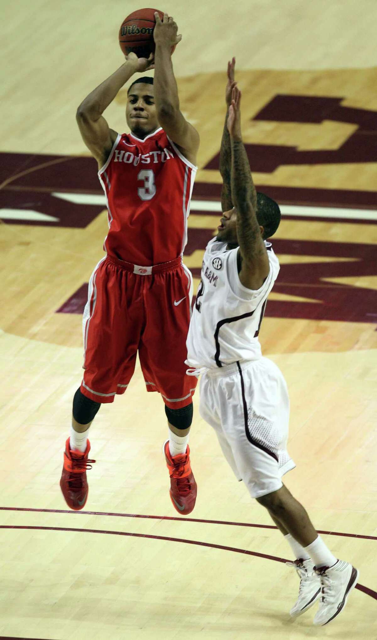 Houston's Jaaron Simmons (3) shoots the ball as Teaxs A&M's Fabyon Harris defends during the second half of an NCAA college basketball game, Wednesday, December 3, 2013, at Reed Arena in College Station, TX.