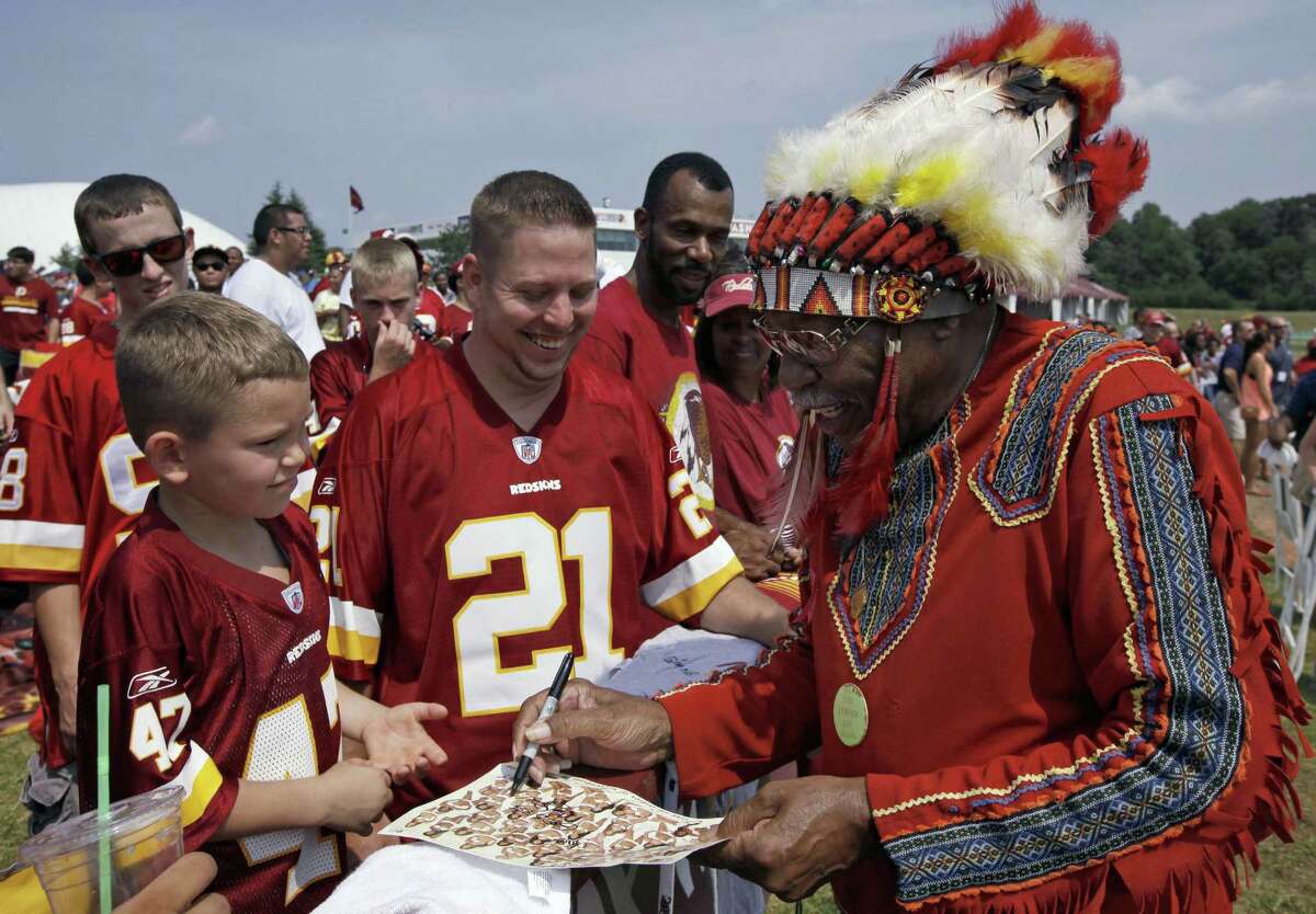 It's all fun and games depending on who's offended. Washing-ton Redskins fan Zena “Chief Z” Williams signs autographs.