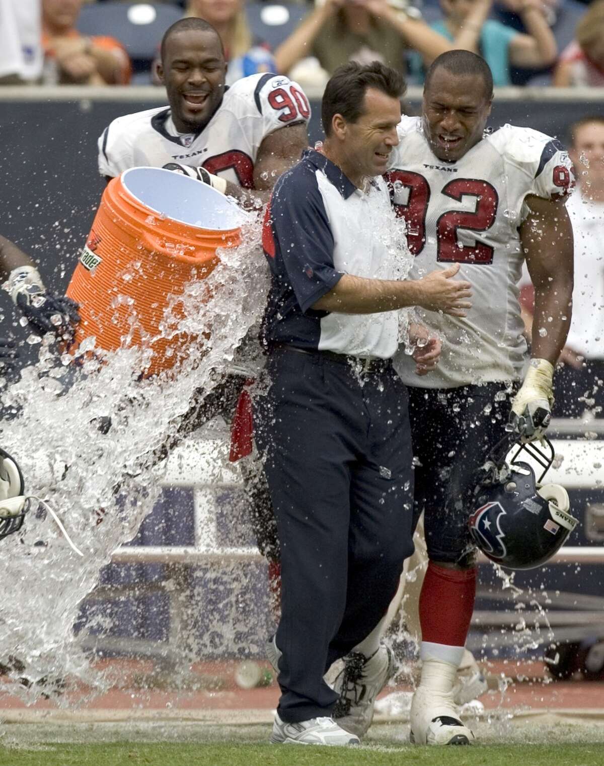 Gary Kubiak, center, is splashed with water by DeMeco Ryans (out of photo), Mario Williams (90) and Anthony Weaver (92) after the Texans beat the Miami Dolphins 17-15 on Oct. 1, 2006 to give Kubiak his first win as Texans coach.