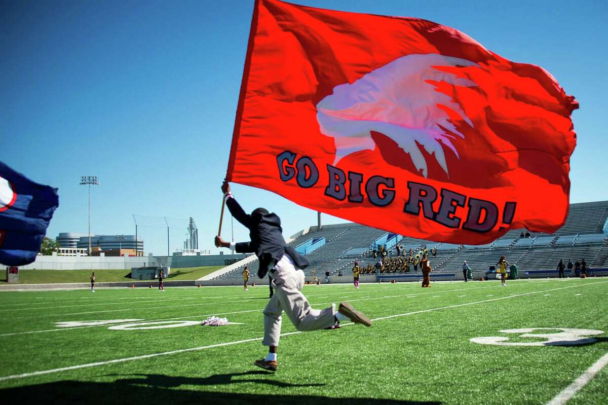 A flag bearing the Lamar High School Redskins mascot is carried across the field before a game against Sam Houston at Delmar Stadium on Saturday, Oct. 19, 2013, in Houston. ( Smiley N. Pool / Houston Chronicle )
