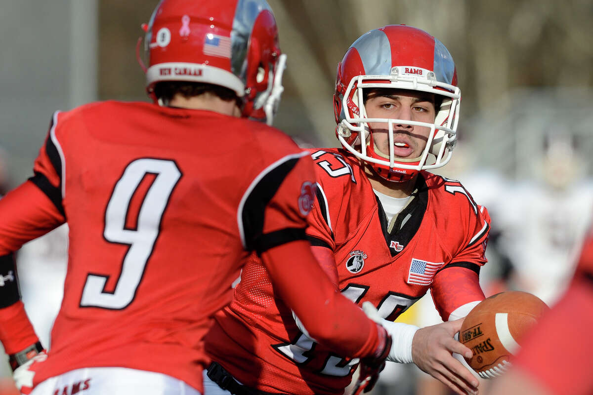 New Canaan's Nick Cascione hands off to Cole Turpin as New Canaan High School challenges North Haven High School in Class L football semifinals at Jonathan Law High School in Milford, CT on Sat., Dec. 7, 2013.