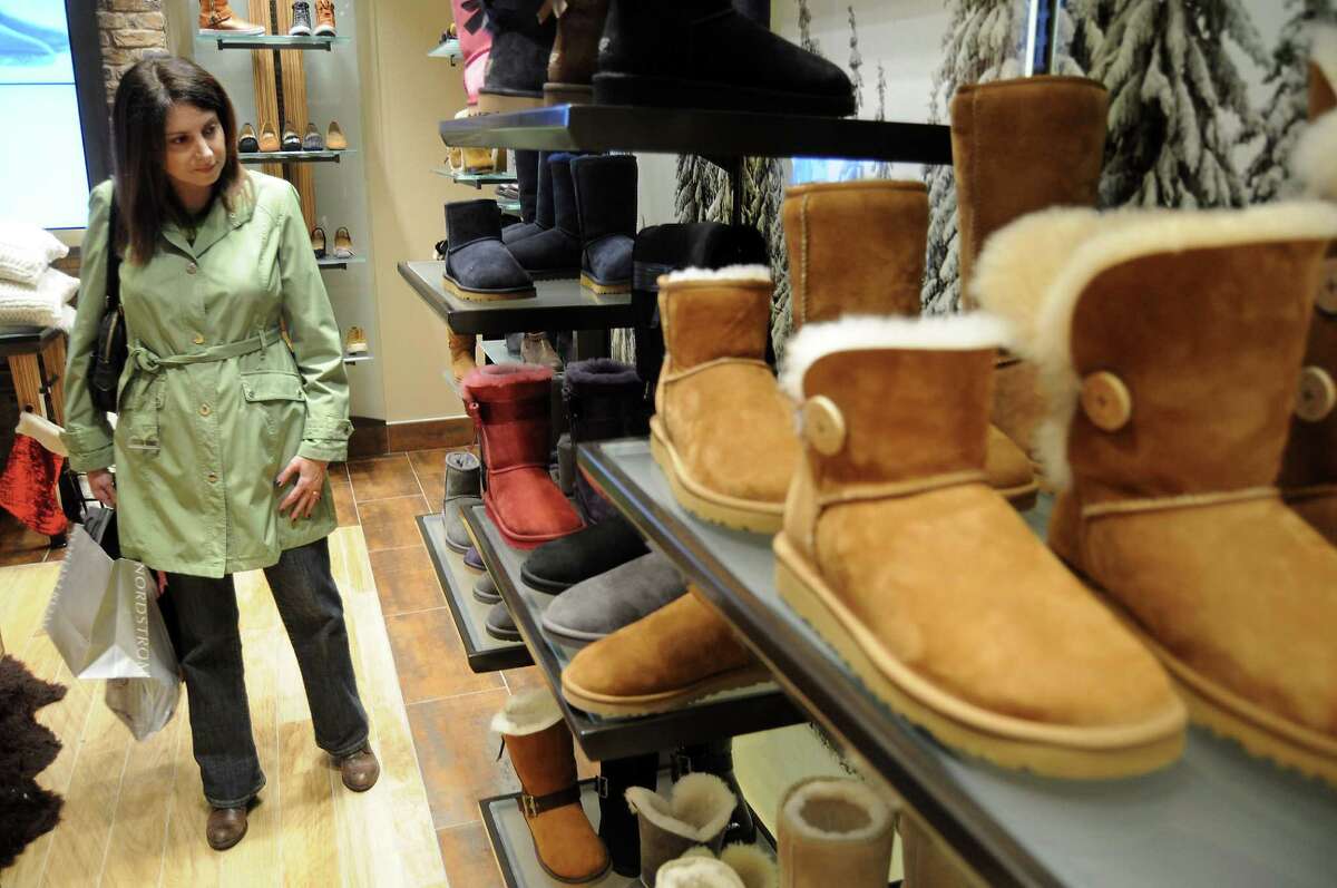 Elise Neal shops for boots at the Ugg store at the Galleria in Houston. One researcher says “the Ugg boot has become a holiday tradition rivaling the fruitcake.”