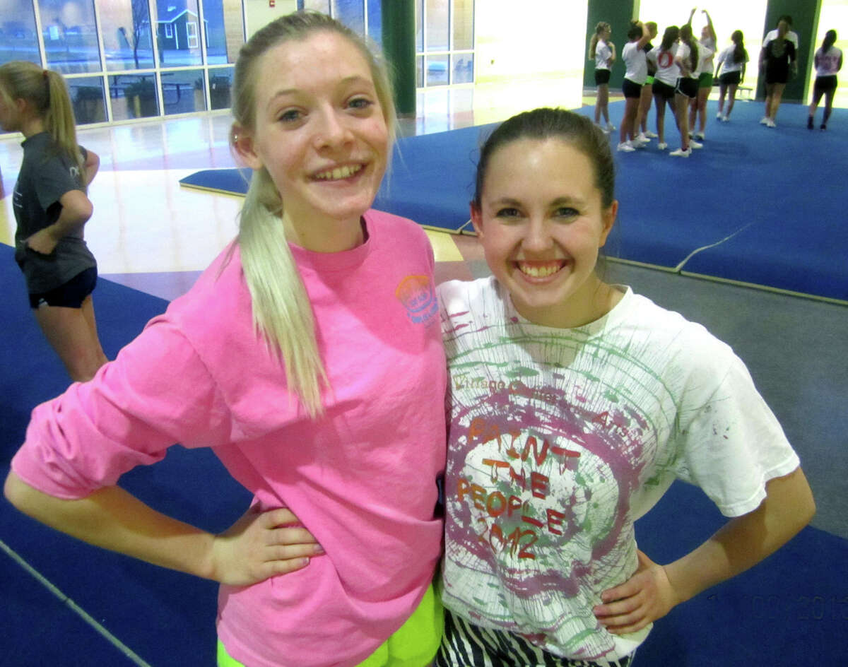 Janna Stratman, left, and Meghan Timan happily shoulder the responsibility of captaining the New Milford High School cheerleading team this winter. Dec. 9, 2013